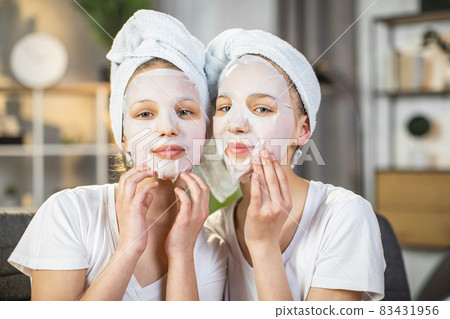 Two sisters posing at home with hydration mask on face 83431956