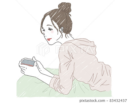 A woman looking at a smartphone while lying down A woman looking at a smartphone while lying down 83432437