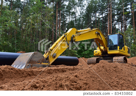Excavator during earthwork for laying Crude oil and Natural gas pipeline in forest area. Excavator during earthwork for laying Crude oil and Natural gas pipeline in forest area. 83433802