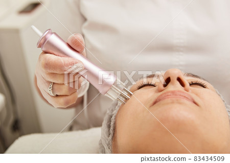 Lovely woman receiving radiofrequency treatment at wellness center Lovely woman receiving radiofrequency treatment at wellness center 83434509