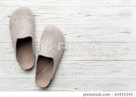 Warm winter women woolen slippers on the floor. Copy space for text Warm winter women woolen slippers on the floor. Copy space for text 83435343
