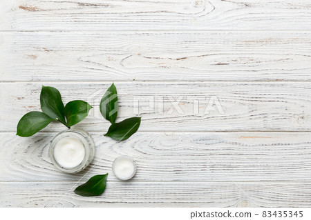 Organic cosmetic products with green leaves on wooden background. Copy space, flat lay Organic cosmetic products with green leaves on wooden background. Copy space, flat lay 83435345