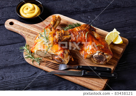 roasted pork shanks on a wood board, top view 83438121