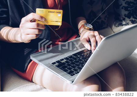 Close up of business woman holding credit card during using laptop for online shopping. Online shopping is the process of buying goods and services from merchants over the Internet. 83438822