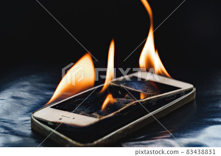 burning broken smartphone on a black background.  83438831