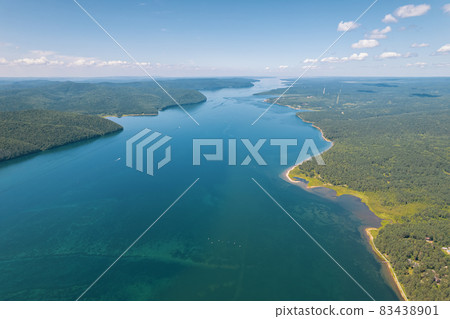 The Angara River is a major river in Siberia leaving Lake Baikal near the settlement of Listvyanka. Panoramic aerial view. 83438901