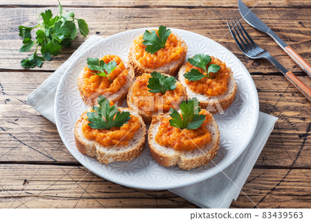 Sandwiches with bread zucchini caviar tomatoes onions. Homemade vegetarian food. Canned stewed vegetable. wooden background Sandwiches with bread zucchini caviar tomatoes onions. Homemade vegetarian food. Canned stewed vegetable. wooden background 83439563