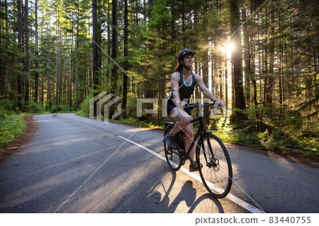 Adventurous Woman Bike Riding on a Trail in Forest Adventurous Woman Bike Riding on a Trail in Forest 83440755
