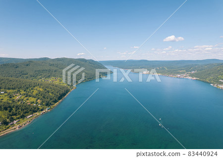The Angara River is a major river in Siberia leaving Lake Baikal near the settlement of Listvyanka. Panoramic aerial view. 83440924