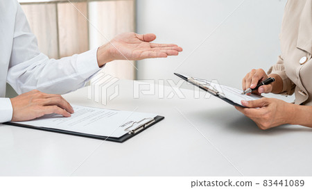 Woman employer is holding to reading resume of applicant during job interview while he is explaining about his profile Woman employer is holding to reading resume of applicant during job interview while he is explaining about his profile 83441089