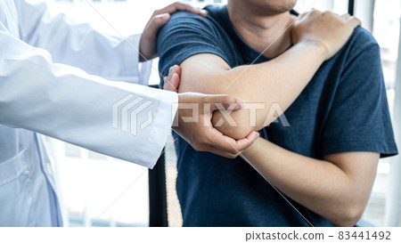 Female physiotherapist doing healing treatment and rehabilitation after injury shoulder of patient by stretching 83441492