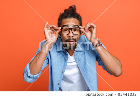 Bad eyesight. Young african american man wearing glasses squinting because of vision troubles Bad eyesight. Young african american man wearing glasses squinting because of vision troubles 83441832