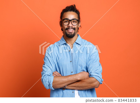 Portrait of young happy smiling african american man in with crossed arms expressing positiveness 83441833