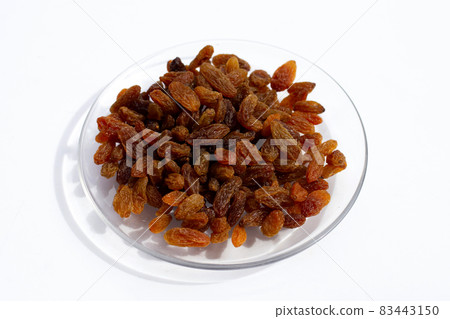 Dried grape raisins in glass plate on white background Dried grape raisins in glass plate on white background 83443150