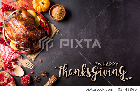 Thanksgiving dinner background concept with turkey roasted and all sides dishes, fall leaves, pumpkin and seasonal autumnal decor with the text on dark stone background. 83443869