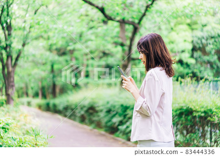 Business woman who uses a smartphone outside Business woman who uses a smartphone outside 83444336