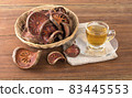 The Bael fruit juice in a glass and dried Bael fruit placed on the wooden 83445553