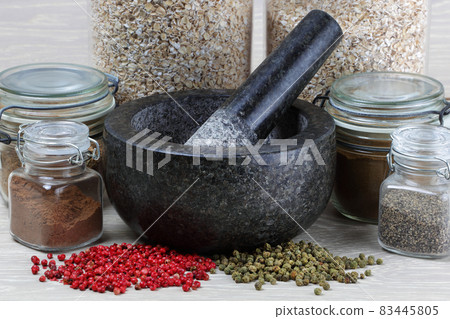 Close up side view of jars of spices and pepper corns ready for grinding Close up side view of jars of spices and pepper corns ready for grinding 83445805