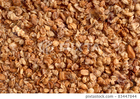 Organic granola with oats, raisins, nuts. Texture of brown muesli flakes as background. Top view. Blank space for text. A backdrop of vegetarian and vegan food for breakfast. Healthy nutrition concept Organic granola with oats, raisins, nuts. Texture of brown muesli flakes as background. Top view. Blank space for text. A backdrop of vegetarian and vegan food for breakfast. Healthy nutrition concept 83447844