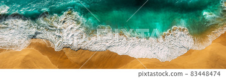 Beautiful sea wave at sunset from a bird's eye view. Beautiful lonely beach at sunset. Aerial view of turquoise ocean waves in Kelingking beach, Nusa penida Island in Bali, Indonesia. Beaches of Bali 83448474
