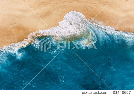 Blue ocean and clean sandy beach. Beautiful sea and wild beach with yellow sand. Blue ocean wave on a sandy beach. Top view of the tropical beach. Paradise island. Copy space 83448607