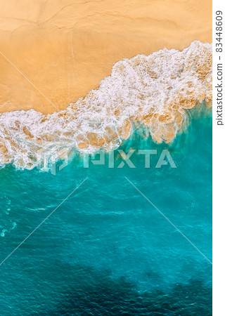 Beautiful sandy beach with turquoise sea, vertical view. Drone view of tropical turquoise ocean beach Nusa penida Bali Indonesia. Lonely sandy beach with beautiful waves. Beaches of Indonesia. 83448609