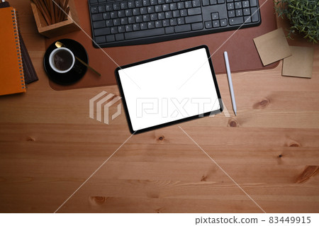 Digital tablet with white screen, stylus pen and coffee cup on wooden table. 83449915