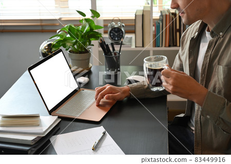 Cropped shot young man working online with laptop computer at home. 83449916