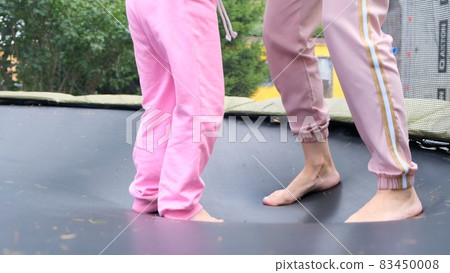 young woman and a young girl are jumping on a ram, close-up. Legs float in the air after jumping on young woman and a young girl are jumping on a ram, close-up. Legs float in the air after jumping on 83450008