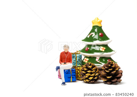 Miniature people , Woman wearing headphones sitting on gift box 83450240