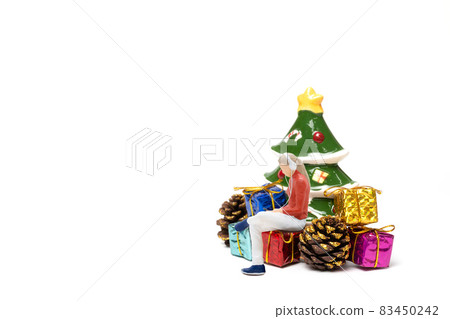 Miniature people , Woman wearing headphones sitting on gift box 83450242
