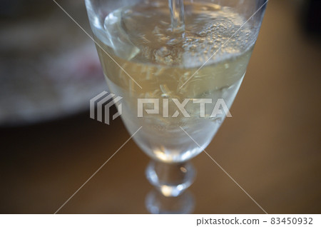 將白葡萄酒倒入玻璃杯中 將白葡萄酒倒入玻璃杯中 83450932