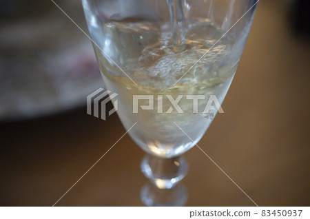 將白葡萄酒倒入玻璃杯中 將白葡萄酒倒入玻璃杯中 83450937