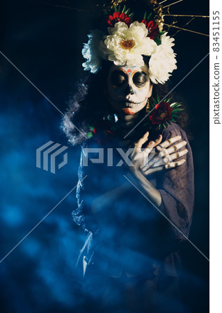 Woman with mexican skull halloween makeup on her face. Day of the dead and halloween Woman with mexican skull halloween makeup on her face. Day of the dead and halloween 83451155