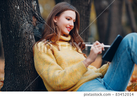 Young woman model in autumn park with yellow foliage maple leaves. Fall season fashion. Young woman model in autumn park with yellow foliage maple leaves. Fall season fashion. 83452014