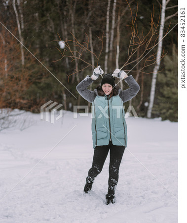 Couple of teenagers building snowman together in winter 83452161