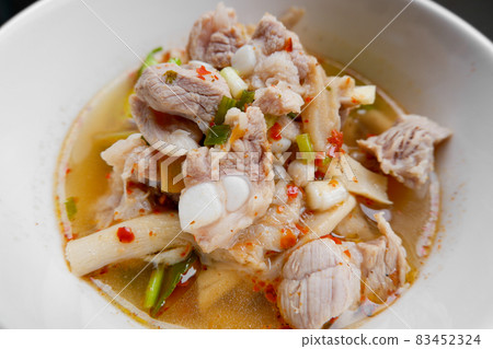 Spicy and sour Thai food called Fiery Pork Ribs Broth. in a white cup on the dining table, close up. 83452324