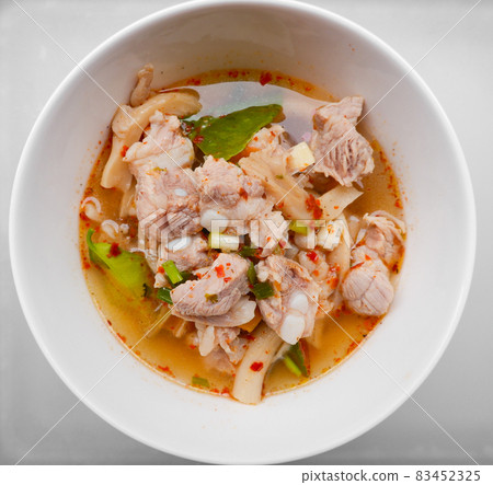 Spicy and sour Thai food called Fiery Pork Ribs Broth. in a white cup on the dining table, Top view. 83452325