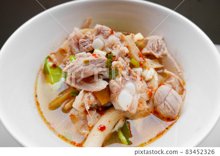 Spicy and sour Thai food called Fiery Pork Ribs Broth. in a white cup on the dining table, close up. 83452326