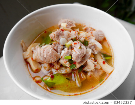 Spicy and sour Thai food called Fiery Pork Ribs Broth. in a white cup on the dining table, close up. 83452327