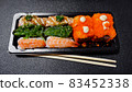 Japanese food called sushi . Rice rolls mixed with shrimp, salmon, and seaweed, food bar on black background 83452338