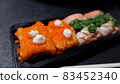 Japanese food called sushi . Rice rolls mixed with shrimp, salmon, and seaweed, food bar on black background 83452340