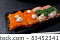 Japanese food called sushi . Rice rolls mixed with shrimp, salmon, and seaweed, food bar on black background 83452341