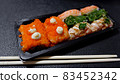 Japanese food called sushi . Rice rolls mixed with shrimp, salmon, and seaweed, food bar on black background 83452342