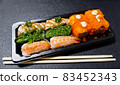 Japanese food called sushi . Rice rolls mixed with shrimp, salmon, and seaweed, food bar on black background 83452343