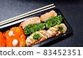 Japanese food called sushi . Rice rolls mixed with shrimp, salmon, and seaweed, food bar on black background 83452351