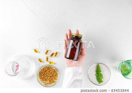 Making herbal dietary supplement in lab with plant leaves. Health and beauty concept Making herbal dietary supplement in lab with plant leaves. Health and beauty concept 83453844