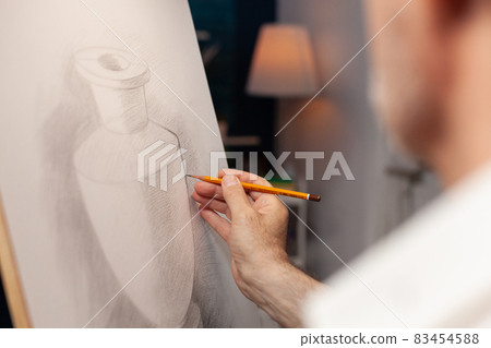 Close up of caucasian hand of old man holding pencil Close up of caucasian hand of old man holding pencil 83454588