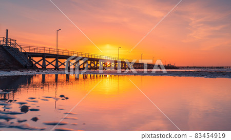 Moonta Bay jetty view at sunset during low tide Moonta Bay jetty view at sunset during low tide 83454919