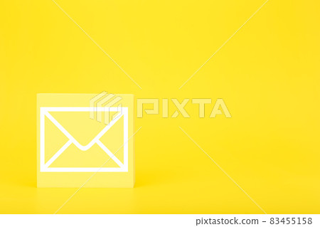 Email marketing or newsletter concept. Envelope drawn on toy square against bright yellow background with copy space Email marketing or newsletter concept. Envelope drawn on toy square against bright yellow background with copy space 83455158